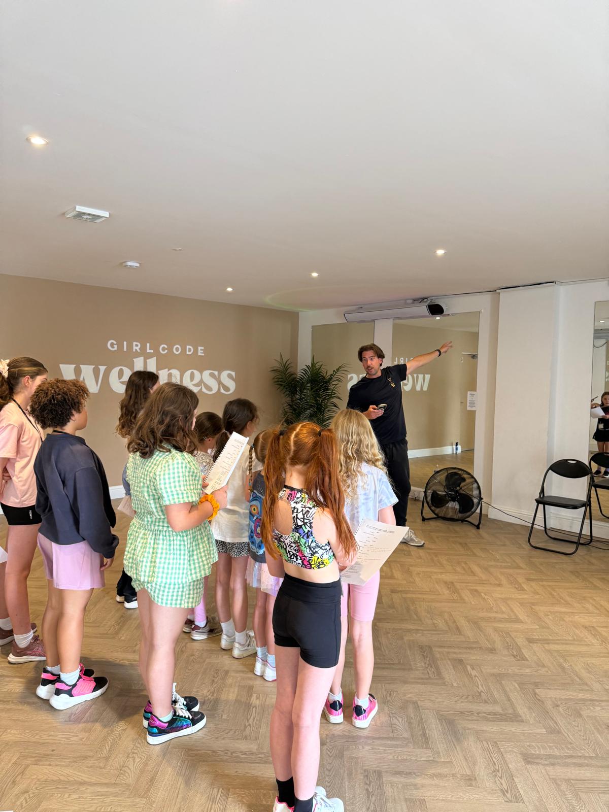 Young performers working together with a workshop leader and printed material